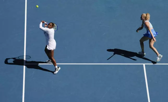 Katerina Sinikova of the Czech Republic and Taylor Townsend, left, of the U.S. in action against Hsieh Su-Wei of Taiwan and Jelena Ostapenko of Latvia in the women's doubles final at the Australian Open tennis championship in Melbourne, Australia, Sunday, Jan. 26, 2025. (AP Photo/Manish Swarup)