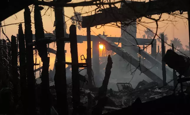 The sun rises and destruction from the Palisades Fire is seen in the Pacific Palisades neighborhood of Los Angeles, Thursday, Jan. 9, 2025. (AP Photo/Damian Dovarganes)