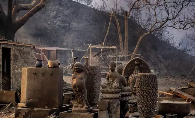 Charred Buddha statues stand amidst other sculptures at burned out shop in Malibu, Calif., Wednesday, Jan. 8, 2025. (AP Photo/Richard Vogel)