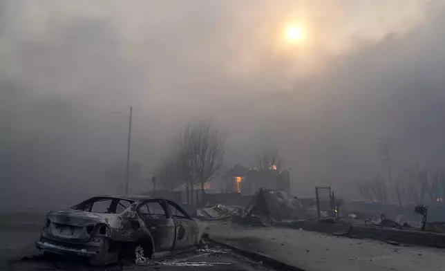 A burned-out car sits among rubble in the downtown Altadena section of Pasadena, Calif., Wednesday, Jan. 8, 2025. (AP Photo/Chris Pizzello)