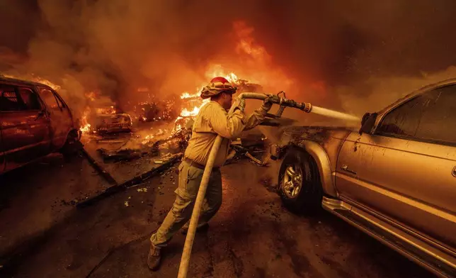 A firefighter battles the Eaton Fire Wednesday, Jan. 8, 2025 in Altadena, Calif. (AP Photo/Ethan Swope)