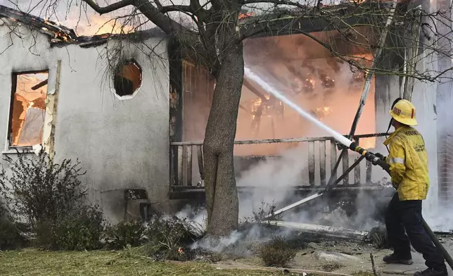 A firefighter battles the Eaton Fire, Wednesday, Jan. 8, 2025, in Altadena, Calif. (AP Photo/Nic Coury)