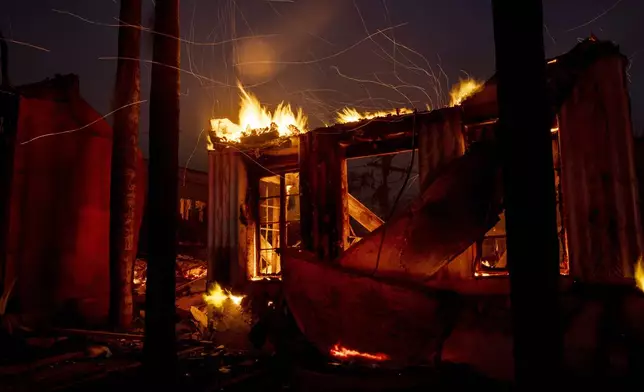 Embers fly from a burning structure during the Eaton fire in Altadena, Calif., Wednesday, Jan. 8, 2025. (Stephen Lam/San Francisco Chronicle via AP)