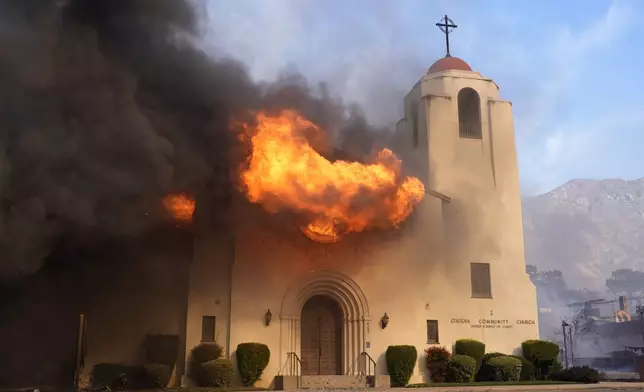 Fire explodes out of a window of the Altadena Community Church, Wednesday, Jan. 8, 2025, in the downtown Altadena section of Pasadena, Calif. (AP Photo/Chris Pizzello)