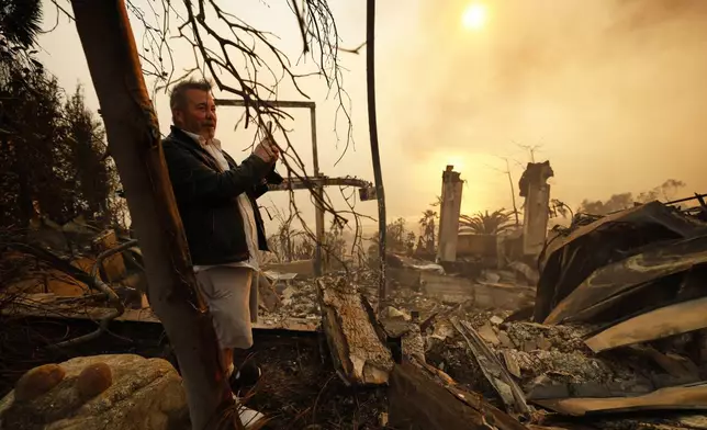 Kelly Kline looks out at his home damaged by the Palisades Fire, Wednesday, Jan. 8, 2025, in Malibu, Calif. (AP Photo/Etienne Laurent)