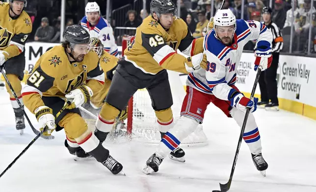 Vegas Golden Knights right wing Mark Stone (61) and center Ivan Barbashev (49) defend against New York Rangers center Sam Carrick (39) during the first period of an NHL hockey game Saturday, Jan. 11, 2025, in Las Vegas. (AP Photo/David Becker)