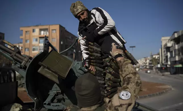 Members of the new security forces reload a heavy machine gun during an operation to detain, according to the state media, militiamen affiliated with ousted president Bashar Assad in Homs, Syria, Thursday, Jan. 2, 2025. (AP Photo/Leo Correa)