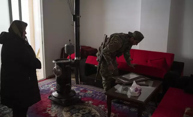 A member of the new security forces searches an apartment during an operation to detain, according to the state media, militiamen affiliated with ousted president Bashar Assad, at a residential area, in Homs, Syria, Thursday, Jan. 2, 2025. (AP Photo/Leo Correa)