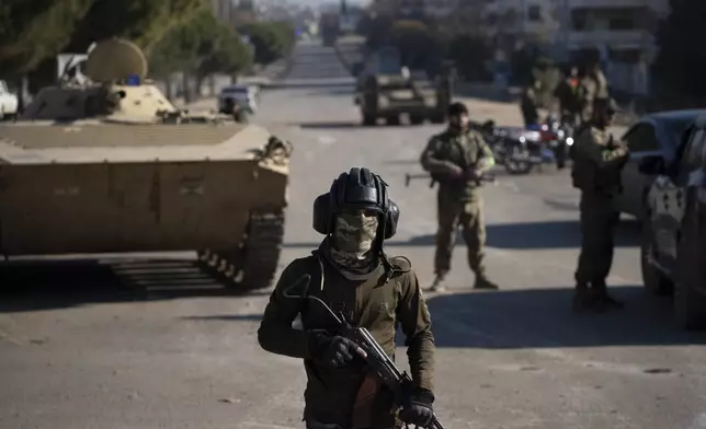 Members of the security forces of the newly formed Syrian government stand in guard as they take part in an operation to detain, according to the state media, militiamen affiliated with ousted president Bashar Assad in Homs, Syria, Thursday, Jan. 2, 2025. (AP Photo/Leo Correa)