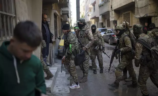 Members of the security forces of the newly formed Syrian government take part in an operation to detain, according to the state media, militiamen affiliated with ousted president Bashar Assad in Homs, Syria, Thursday, Jan. 2, 2025. (AP Photo/Leo Correa)