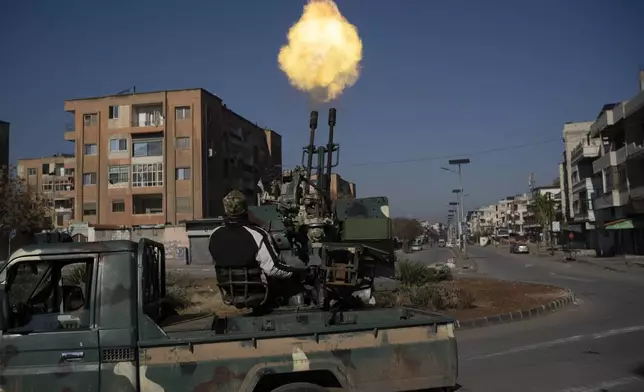 A member of the new security forces fires a heavy machine gun into the sky to display strength during an operation to detain, according to the state media, militiamen affiliated with ousted president Bashar Assad in Homs, Syria, Thursday, Jan. 2, 2025. (AP Photo/Leo Correa)