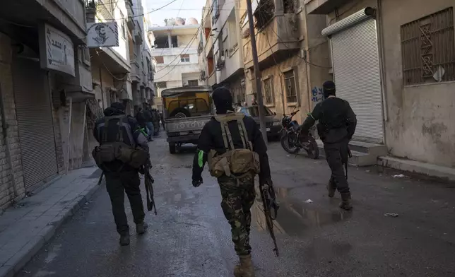 Members of the security forces of the newly formed Syrian government take part in an operation to detain, according to the state media, militiamen affiliated with ousted president Bashar Assad at a residential area in Homs, Syria, Thursday, Jan. 2, 2025. (AP Photo/Leo Correa)