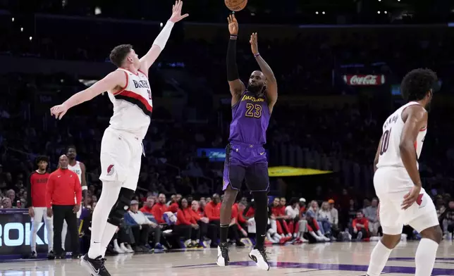 Los Angeles Lakers forward LeBron James, center, shoots as Portland Trail Blazers center Donovan Clingan, left, and guard Scoot Henderson defend during the first half of an NBA basketball game, Thursday, Jan. 2, 2025, in Los Angeles. (AP Photo/Mark J. Terrill)