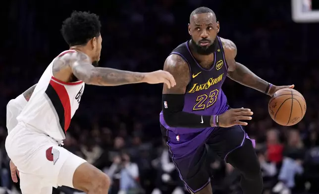 Los Angeles Lakers forward LeBron James, right, drives by Portland Trail Blazers guard Anfernee Simons during the first half of an NBA basketball game, Thursday, Jan. 2, 2025, in Los Angeles. (AP Photo/Mark J. Terrill)