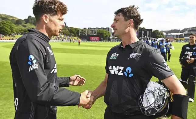 New Zealand's Mitchell Santner and Will Young shake hands following the first ODI international cricket match between New Zealand and Sri Lanka at the Basin Reserve in Wellington, New Zealand Sunday, Jan. 5, 2025. (Kerry Marshall/Photosport via AP)