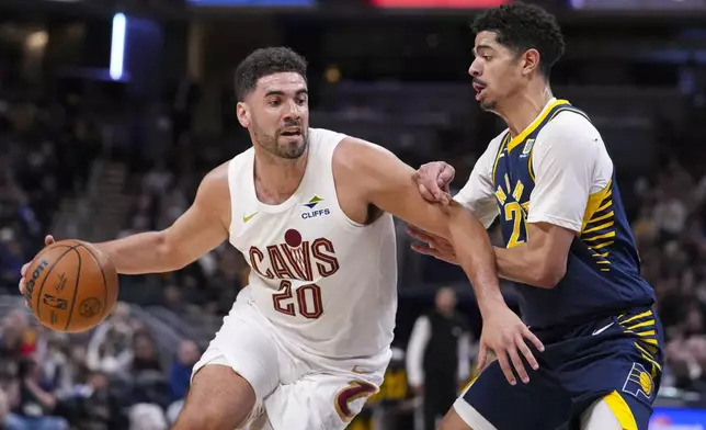 Cleveland Cavaliers forward Georges Niang (20) drives on Indiana Pacers guard Ben Sheppard (26) during the second half of an NBA basketball game in Indianapolis, Tuesday, Jan. 14, 2025. (AP Photo/Michael Conroy)