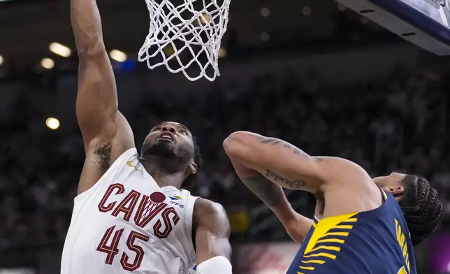 Cleveland Cavaliers guard Donovan Mitchell (45) tips in the ball over Indiana Pacers forward Obi Toppin (1) during the second half of an NBA basketball game in Indianapolis, Tuesday, Jan. 14, 2025. (AP Photo/Michael Conroy)