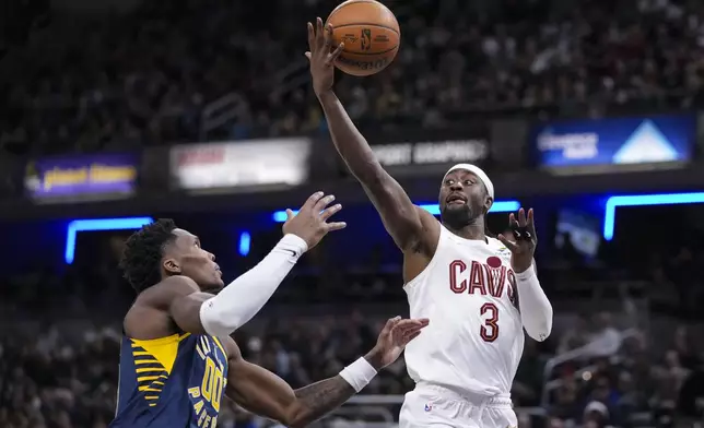 Cleveland Cavaliers guard Caris LeVert (3) grabs a rebound over Indiana Pacers guard Bennedict Mathurin (00) during the second half of an NBA basketball game in Indianapolis, Tuesday, Jan. 14, 2025. (AP Photo/Michael Conroy)