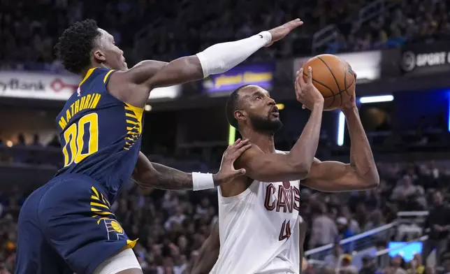 Indiana Pacers guard Bennedict Mathurin (00) tries to stop the shot of Cleveland Cavaliers forward Evan Mobley (4) during the second half of an NBA basketball game in Indianapolis, Tuesday, Jan. 14, 2025. (AP Photo/Michael Conroy)