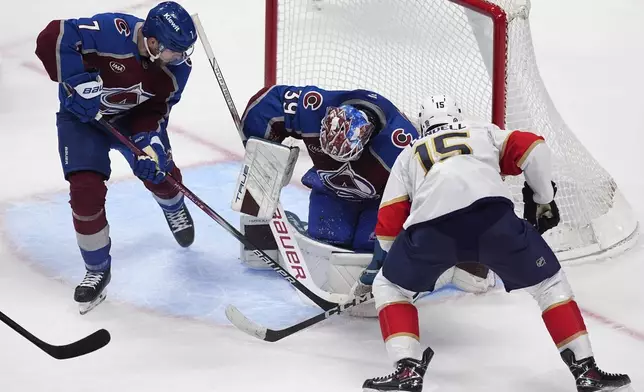 Florida Panthers center Anton Lundell, right, shoots against Colorado Avalanche goaltender Mackenzie Blackwood, center, as Avalanche defenseman Devon Toews, left, covers in the third period of an NHL hockey game Monday, Jan. 6, 2025, in Denver. (AP Photo/David Zalubowski)