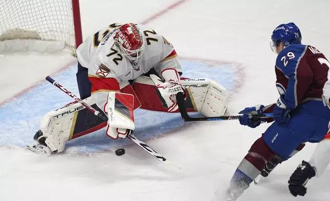 Florida Panthers goaltender Sergei Bobrovsky, left, makes a stick-save against a shot by Colorado Avalanche center Nathan MacKinnon (29) in the first period of an NHL hockey game Monday, Jan. 6, 2025, in Denver. (AP Photo/David Zalubowski)