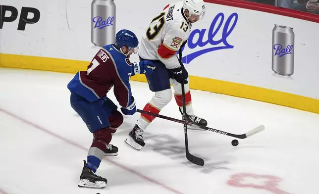 Colorado Avalanche defenseman Devon Toews, left, fights for control of the puck with Florida Panthers center Sam Reinhart, right, in the first period of an NHL hockey game Monday, Jan. 6, 2025, in Denver. (AP Photo/David Zalubowski)