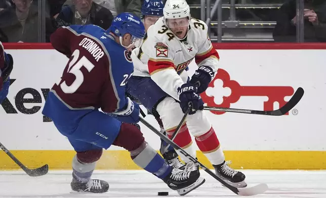 Florida Panthers defenseman Adam Boqvist, right, fights for control of the puck with Colorado Avalanche right wing Logan O'Connor, left, in the second period of an NHL hockey game Monday, Jan. 6, 2025, in Denver. (AP Photo/David Zalubowski)