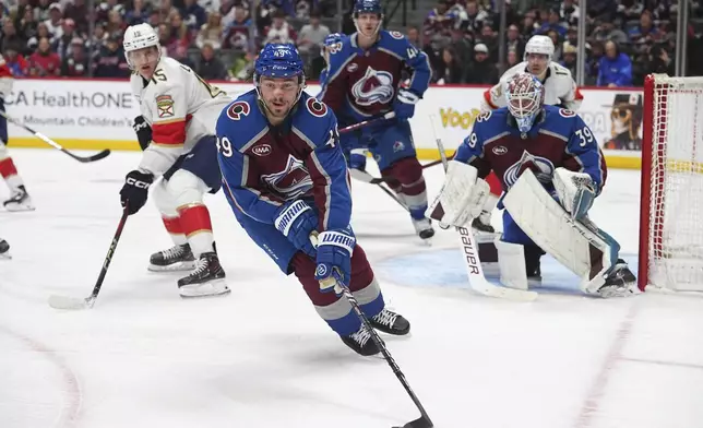 Colorado Avalanche defenseman Samuel Girard, front, collects the puck as Colorado Avalanche goaltender Mackenzie Blackwood (39) and Florida Panthers center Anton Lundell (15) watch in the second period of an NHL hockey game Monday, Jan. 6, 2025, in Denver. (AP Photo/David Zalubowski)