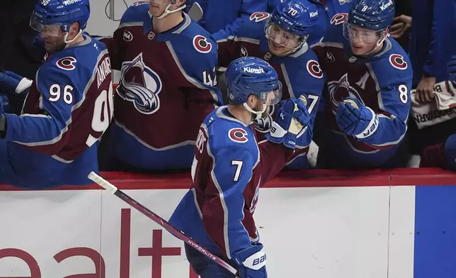 Colorado Avalanche defenseman Devon Toews (7) is congratulated as he passes the team box after scoring in the third period of an NHL hockey game against the Florida Panthers, Monday, Jan. 6, 2025, in Denver. (AP Photo/David Zalubowski)