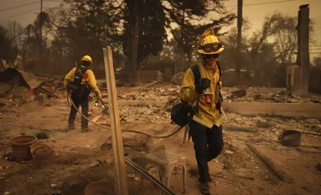 Firefighters looks for hot spots in a fire-ravaged property in the aftermath of the Eaton Fire Thursday, Jan. 9, 2025 in Altadena, Calif. (AP Photo/Eric Thayer)