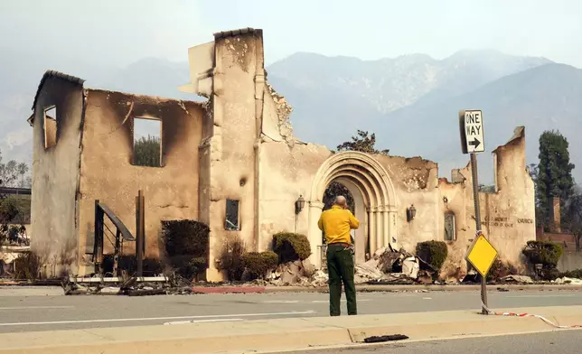 A man photographs the destroyed Altadena Community Church, Thursday, Jan. 9, 2025, in the Altadena section of Pasadena, Calif. (AP Photo/Chris Pizzello)