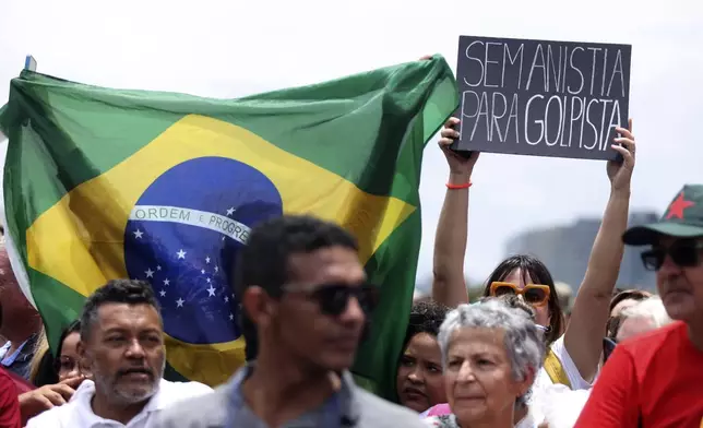 A protester holds up a sign that says in Portuguese "No Amnesty for Coup Leaders" during a pro-democracy event on the second anniversary of the alleged coup attempt when supporters of former President Jair Bolsonaro invaded government buildings and called for military intervention in Brasilia, Brazil, Wednesday, Jan. 8, 2025. (AP Photo/Luis Nova)