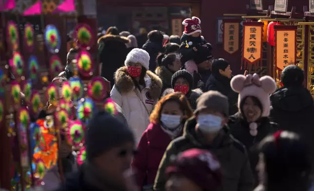 People tour by stores as they visit a temple fair held at the Dongyue Temple on the first day of the Chinese Lunar New Year in Beijing on Wednesday, Jan. 29, 2025. (AP Photo/Andy Wong)