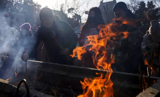 People burn incense as they offer prayer on the first day of the Chinese Lunar New Year at the Dongyue Temple in Beijing on Wednesday, Jan. 29, 2025. (AP Photo/Andy Wong)