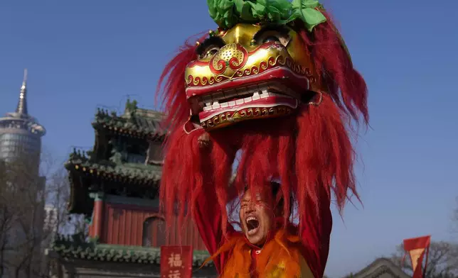 An artist shouts as he performs an acrobatic lion dance at the Dongyue Temple on the first day of the Chinese Lunar New Year in Beijing on Wednesday, Jan. 29, 2025. (AP Photo/Andy Wong)