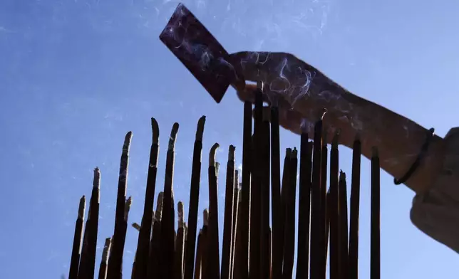 A visitor offers prayer at a Chinese temple to celebrate the Chinese Lunar New Year which marks the Year of the Snake on the Chinese zodiac Wednesday, Jan. 29, 2025, at China Town in Yokohama, south of Tokyo. (AP Photo/Eugene Hoshiko)