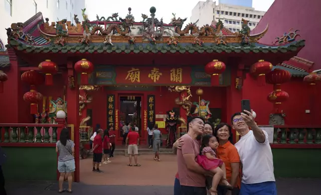 A Malaysian ethnic Chinese family takes picture on the first day of Lunar New Year at Guandi Temple, in Kuala Lumpur, Malaysia, Wednesday, Jan. 29, 2025. (AP Photo/Vincent Thian)