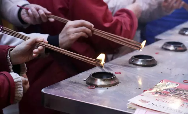 Worshippers burn incense sticks to pray at a temple on the first day of the Lunar New Year celebrations in Taipei, Taiwan, Wednesday, Jan. 29, 2025. (AP Photo/Chiang Ying-ying)