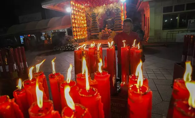 An Ethnic Chinese Thai lights joss sticks at Trai Mit Temple to celebrate the Lunar New Year in Bangkok, Thailand, Wednesday, Jan. 29, 2025. (AP Photo/Sakchai Lalit)