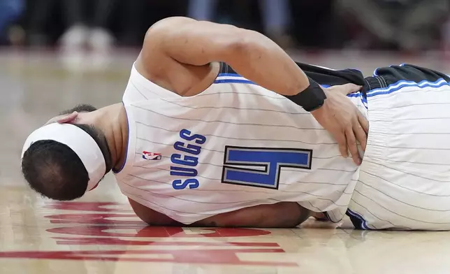 Orlando Magic guard Jalen Suggs (4) holds his back as he lays on the court after suffering an injury during the first half of an NBA basketball game against the Toronto Raptors, Friday, Jan. 3, 2025 in Toronto. (Frank Gunn/The Canadian Press via AP)