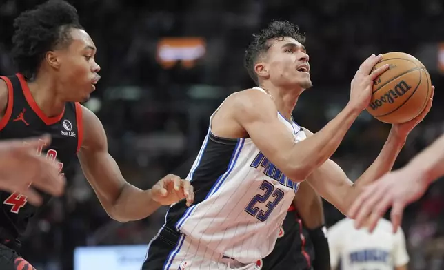 Orlando Magic forward Tristan da Silva (23) drives to the net as Toronto Raptors forward Scottie Barnes (4) defends during second-half NBA basketball game action in Toronto, Friday, Jan. 3, 2025. (Frank Gunn/The Canadian Press via AP)