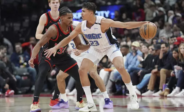 Orlando Magic forward Tristan da Silva (23) dribbles the ball as Toronto Raptors guard Ochai Agbaji (30) defends during the first half of an NBA basketball game, Friday, Jan. 3, 2025 in Toronto. (Frank Gunn/The Canadian Press via AP)