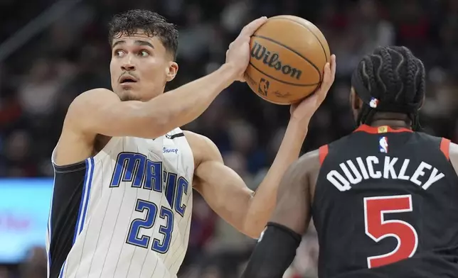 Orlando Magic forward Tristan da Silva (23) looks to pass the ball as Toronto Raptors guard Immanuel Quickley (5) defends during second-half NBA basketball game action in Toronto, Friday, Jan. 3, 2025. (Frank Gunn/The Canadian Press via AP)