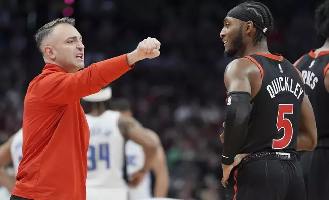 Toronto Raptors head coach Darko Rajakovic, left, talks to guard Immanuel Quickley (5) during a timeout in second-half NBA basketball game action against the Orlando Magic in Toronto, Friday, Jan. 3, 2025. (Frank Gunn/The Canadian Press via AP)