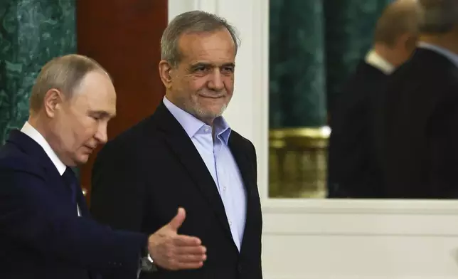 Russian President Vladimir Putin, left, gestures next to Iranian President Masoud Pezeshkian as they attend a signing ceremony at the Kremlin in Moscow, Russia, Friday, Jan. 17, 2025. (Evgenia Novozhenina/Pool Photo via AP)