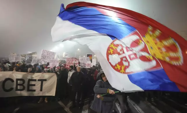 Students march on New Years Eve during a protest that erupted after a concrete canopy fell two months ago and killed 15 people in Belgrade, Serbia, Tuesday, Dec. 31, 2024. (AP Photo/Darko Vojinovic)