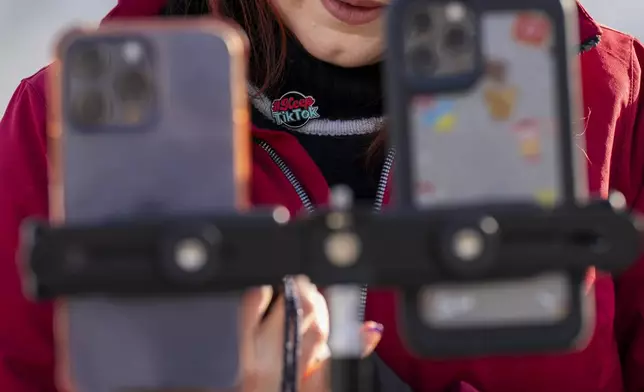 Wearing a button in support of TikTok, Tiffany Cianci, who says she is a "long-form educational content creator," livestreams to TikTok outside the Supreme Court, Friday, Jan. 10, 2025, in Washington. (AP Photo/Jacquelyn Martin)