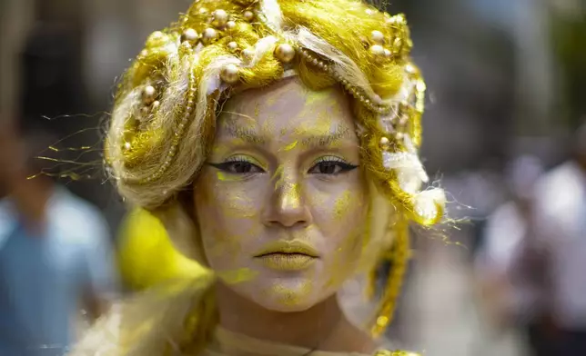 An actress representing the gold of the Three Wise Men poses for a photo during an event celebrating the upcoming holiday of Epiphany in the Plaza de Armas of Santiago, Chile, Sunday, Jan. 5, 2025. (AP Photo/Esteban Felix)