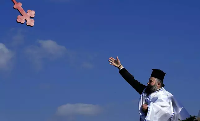 A Christian orthodox priest throws the cross into the sea water, during an epiphany ceremony to bless the sea, on the southeast village of Xylophagou, Cyprus, Monday, Jan. 6, 2025. (AP Photo/Petros Karadjias)