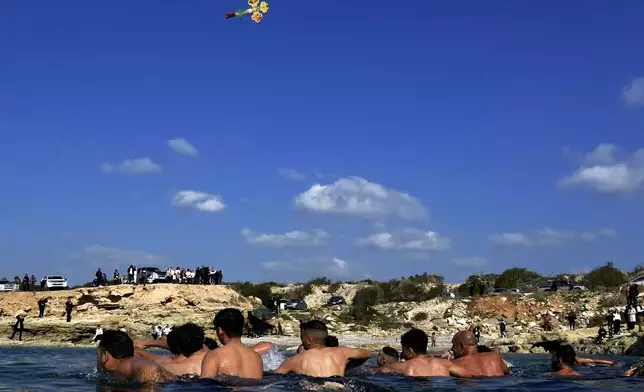 Pilgrim swimmers in the sea waters, prepare as the cross is thrown by a Christian orthodox priest, during an epiphany ceremony to bless the sea, on the southeast village of Xylophagou, Cyprus, Monday, Jan. 6, 2025. (AP Photo/Petros Karadjias)